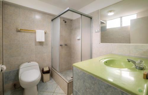 a bathroom with a toilet and a sink and a shower at Hotel Country Trujillo in Trujillo