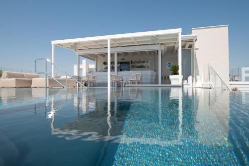 a villa with a swimming pool and a house at Unico Hotel Caorle in Caorle