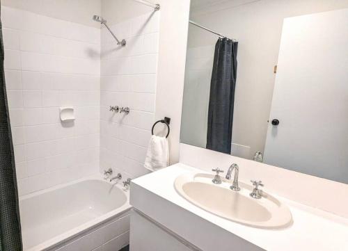 a white bathroom with a sink and a tub at Boutique Home Close to Town and Nature in Bunbury