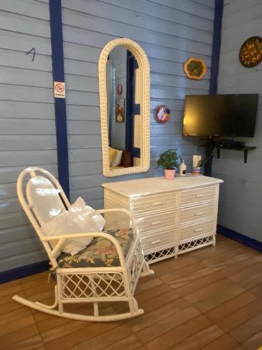 Campito Loving في Higuey: غرفة بها كرسي ومرآة وخزانة