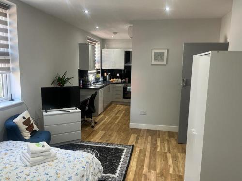 a bedroom with a bed and a kitchen at Grand Bleu - London - Next to Piccadilly Line Tube Station & Brand New Facilities in London