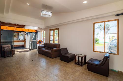 a living room with leather chairs and a waiting room at Hotel Country Trujillo in Trujillo