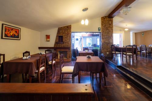 a restaurant with tables and chairs and a fireplace at Hotel Country Trujillo in Trujillo