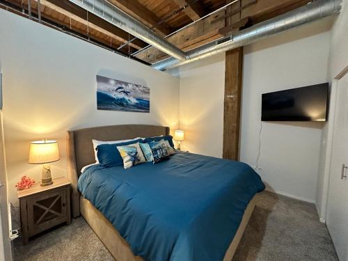 a bedroom with a blue bed and a television at Luxéry Stay Chicago - Across from McCormick Place & Wintrust Arena in Chicago