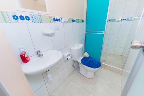 ein Bad mit einem WC, einem Waschbecken und einer Dusche in der Unterkunft Edificio Rojo Departamentos. in Tarapoto
