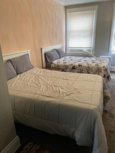 1 Schlafzimmer mit 2 Betten und 2 Fenstern in der Unterkunft Charming 3 bedroom apartment midtown in Cincinnati