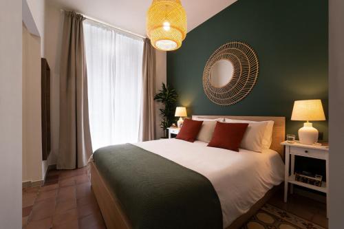 a bedroom with a large bed and a green wall at Kondo Maisons in Catania