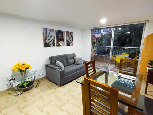 ein Wohnzimmer mit einem Sofa und einem Glastisch in der Unterkunft Apartamento en Laureles con Excelente Ubicación in Medellín