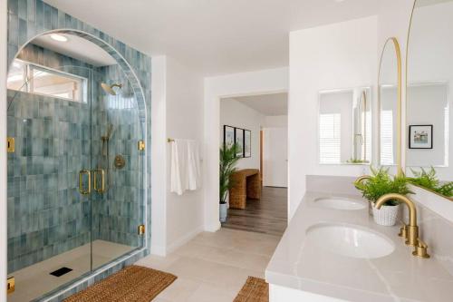 een badkamer met 2 wastafels en een glazen douche bij Backyard Pool Oasis @ Tropicale Blue in Coachella