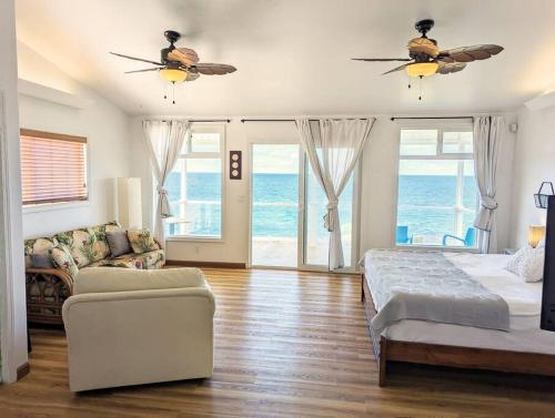 a bedroom with a bed and a couch and a ceiling fan at Maka'Ala Lani - A view of Heaven in Keaau