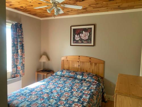 una camera con letto e ventilatore a soffitto di Brudenell Fairway Chalets a Georgetown