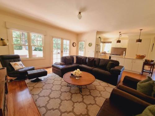 a living room with a couch and a table at Noonan House, 5 bedrooms. Hop & skip to town in Woodend