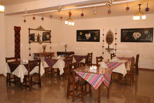 ein Restaurant mit Tischen und Stühlen in einem Zimmer in der Unterkunft Astromelia Hotel in Ayacucho
