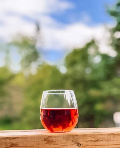 a glass of red wine sitting on a wooden table at Scandi Inspired 2 Bed Suite Sandbanks Pass Incl in Picton