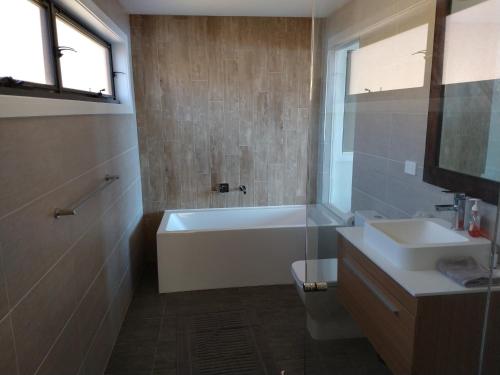 y baño con bañera y lavamanos. en Willow Bay Lodge en Jindabyne
