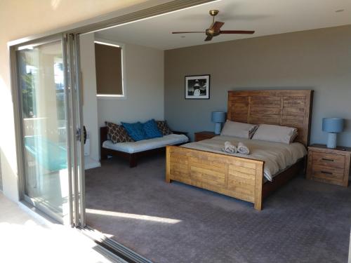 1 dormitorio con 1 cama grande y 1 sofá en Willow Bay Lodge en Jindabyne