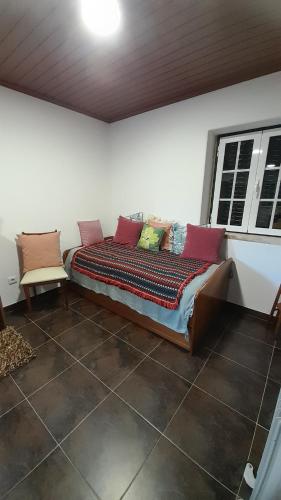 a bed with pillows on it in a room at Casa da Magnólia in Raposeira