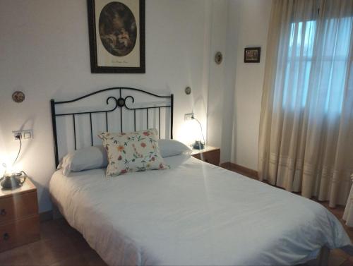 a bedroom with a large white bed with a pillow at Adosado con Patio Punta Umbria in Punta Umbría