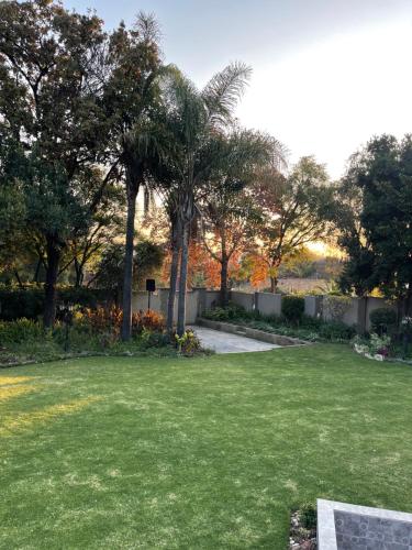 ein Park mit Bäumen und einem Rasenplatz in der Unterkunft OneOnArumAvenue in Johannesburg