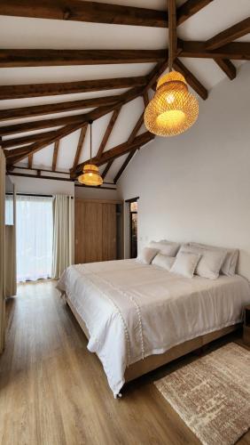 1 dormitorio con 1 cama grande, suelo de madera y techo de madera. en Boho Home - Casa Campestre, Respira Naturaleza!, en Sáchica