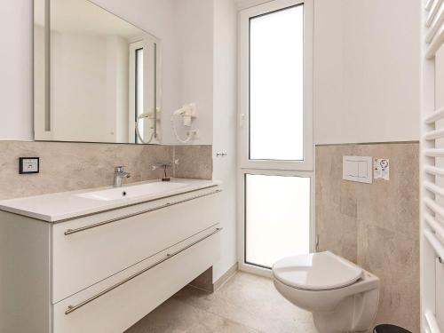 ein weißes Badezimmer mit Waschbecken und Toilette in der Unterkunft 6 person holiday home in Wendtorf in Wendtorf