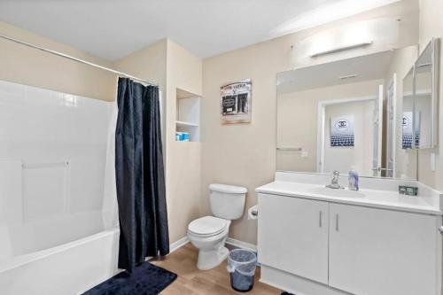 a white bathroom with a toilet and a sink at Lovely & coxy 2BR/2BA! 5MIN to Disney! in Anaheim