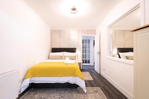 een slaapkamer met een geel bed in een witte kamer bij Paddington House in Londen