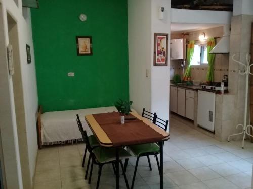comedor con mesa y pared verde en Departamentos del Puerto Verde en Paraná