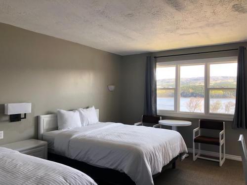 pokój hotelowy z 2 łóżkami i oknem w obiekcie Duck Cove Inn w mieście Margaree Harbour