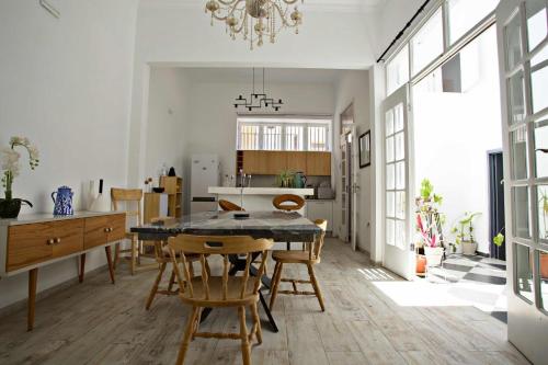 a kitchen and dining room with a table and chairs at As Hortênsias in Mindelo