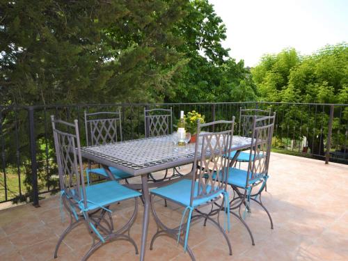 een tafel met vier stoelen en een tafel en een stoeltje bij Flat with private pool in the heart of nature in Malaucène