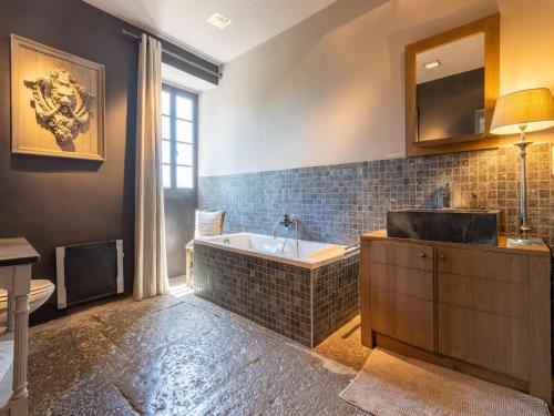 une salle de bain avec une baignoire et un lavabo dans l'établissement Holiday Home in Ardèche with Private Pool, à Labeaume
