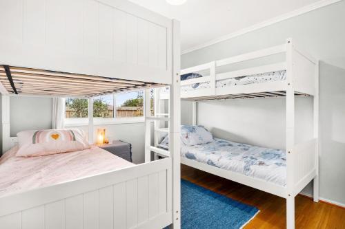 Surf BeachにあるCalm 3922のベッドルーム1室(白い二段ベッド、青いラグ付)