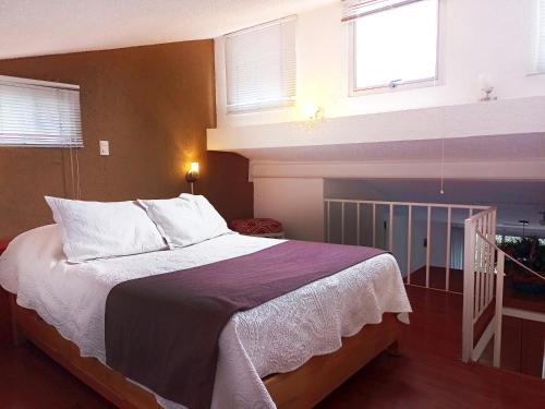 1 dormitorio con 1 cama grande con sábanas y almohadas blancas en Suite 3C, Jacaranda, Garden House, Wewlcome to San Angel, en Ciudad de México