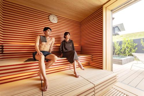 a man and a woman sitting in a sauna at Garden Terrace Nagasaki Hotels & Resorts in Nagasaki