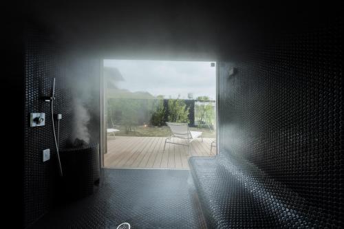 a bathroom with a door open to a patio with a chair at Garden Terrace Nagasaki Hotels & Resorts in Nagasaki