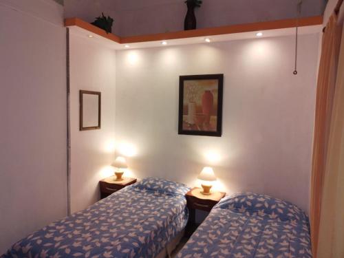 2 camas en una habitación con 2 lámparas en Departamentos del Puerto en Paraná