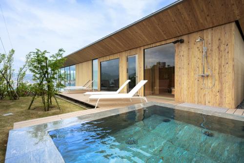 a swimming pool in front of a house at Garden Terrace Nagasaki Hotels & Resorts in Nagasaki