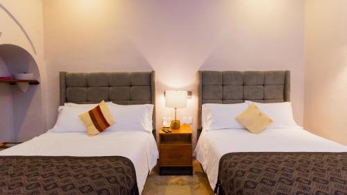 two beds in a room with two beds sidx sidx sidx at Casa Eva Hotel Boutique & Spa in Cholula