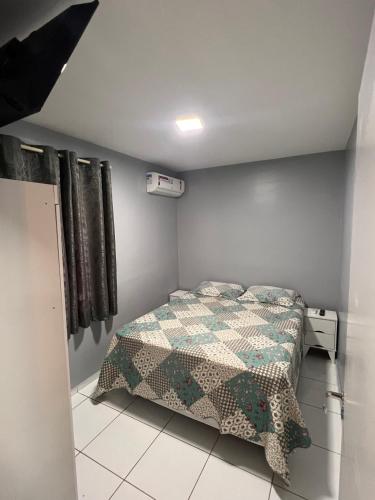 a bedroom with a bed with a quilt on it at Apartamento Mobiliado em Petrolina - Recomendado! in Petrolina