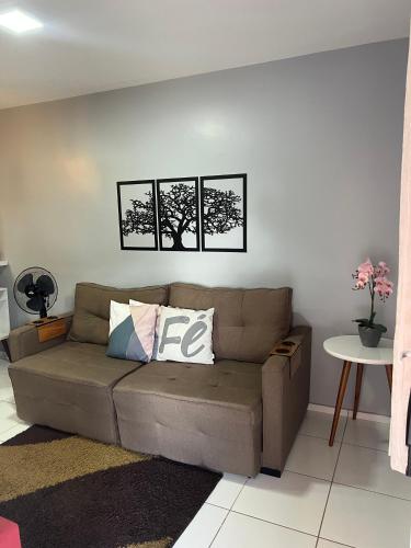 un sofá en una sala de estar con tres cuadros en la pared en Apartamento Mobiliado em Petrolina - Recomendado!, en Petrolina