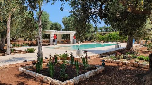 een zwembad in een tuin met bomen en planten bij TRULLO ALLA CASINA GIUSEPPINA in Francavilla Fontana