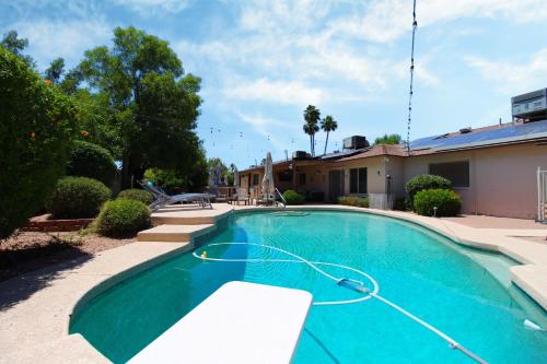 a swimming pool with a hose in front of a house at Luxurious Scottsdale Guesthouse by the Pool in Phoenix