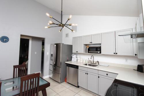 a kitchen with white cabinets and a stainless steel refrigerator at Luxurious Scottsdale Guesthouse by the Pool in Phoenix