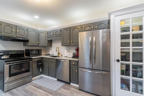 a kitchen with gray cabinets and stainless steel appliances at Luxurious Retreat, Parking, Restaurants, Near New Hope, 1mile Delaware River in Lambertville