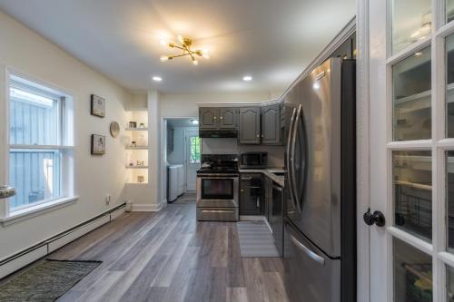 a kitchen with a stainless steel refrigerator and wooden floors at Luxurious Retreat, Parking, Restaurants, Near New Hope, 1mile Delaware River in Lambertville