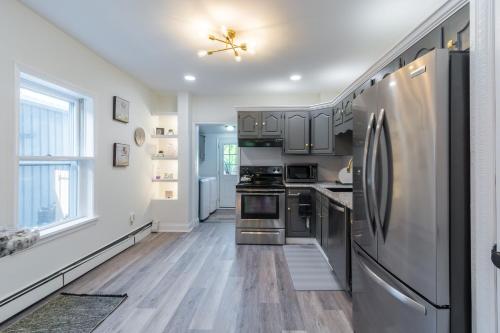 a kitchen with stainless steel appliances and wooden floors at Luxurious Retreat, Parking, Restaurants, Near New Hope, 1mile Delaware River in Lambertville
