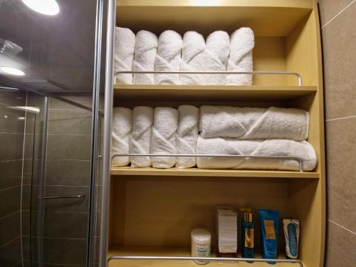 釜山的住宿－Elbon The Stay，浴室内带白色毛巾和书籍的衣柜