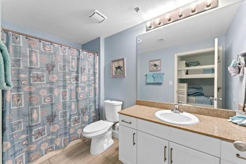 a bathroom with a toilet and a shower curtain at Beautiful Panama City Beach Condo- Ocean View! in Panama City Beach
