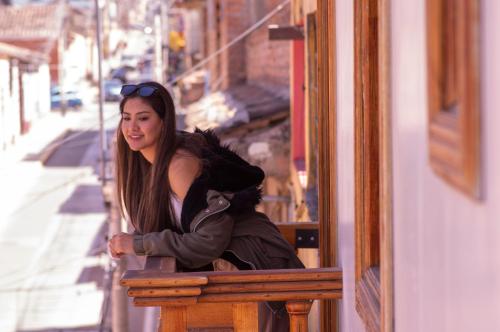 een jonge vrouw die op een vensterbank zit bij Hotel Melthon Class in Ayacucho